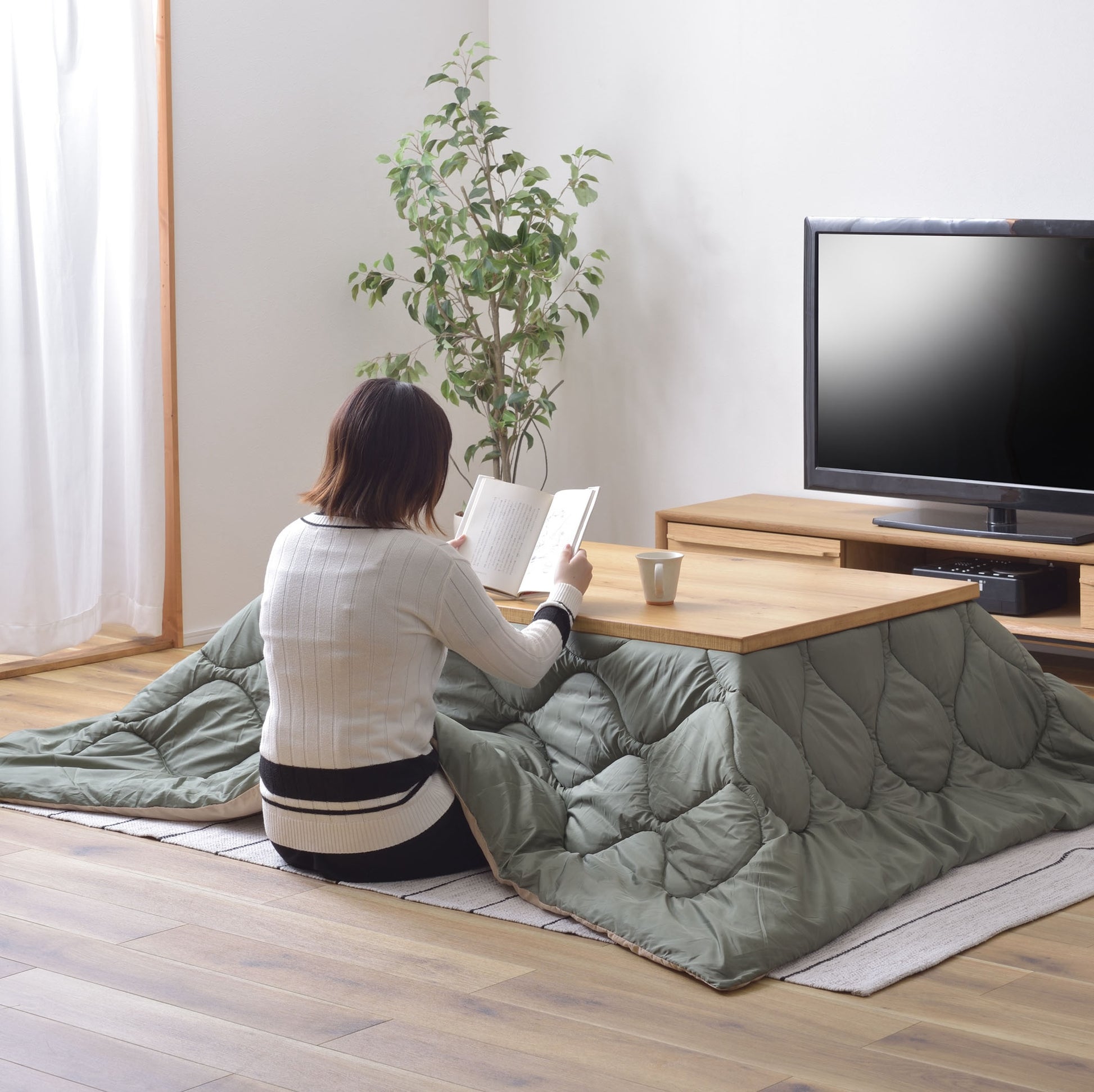 ライトグリーンのキルティング素材のこたつ布団を挟んだこたつテーブル