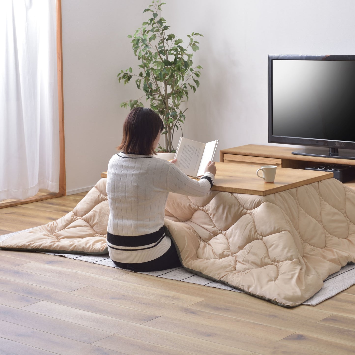 オフホワイトのキルティング素材のこたつ布団を挟んだこたつテーブル