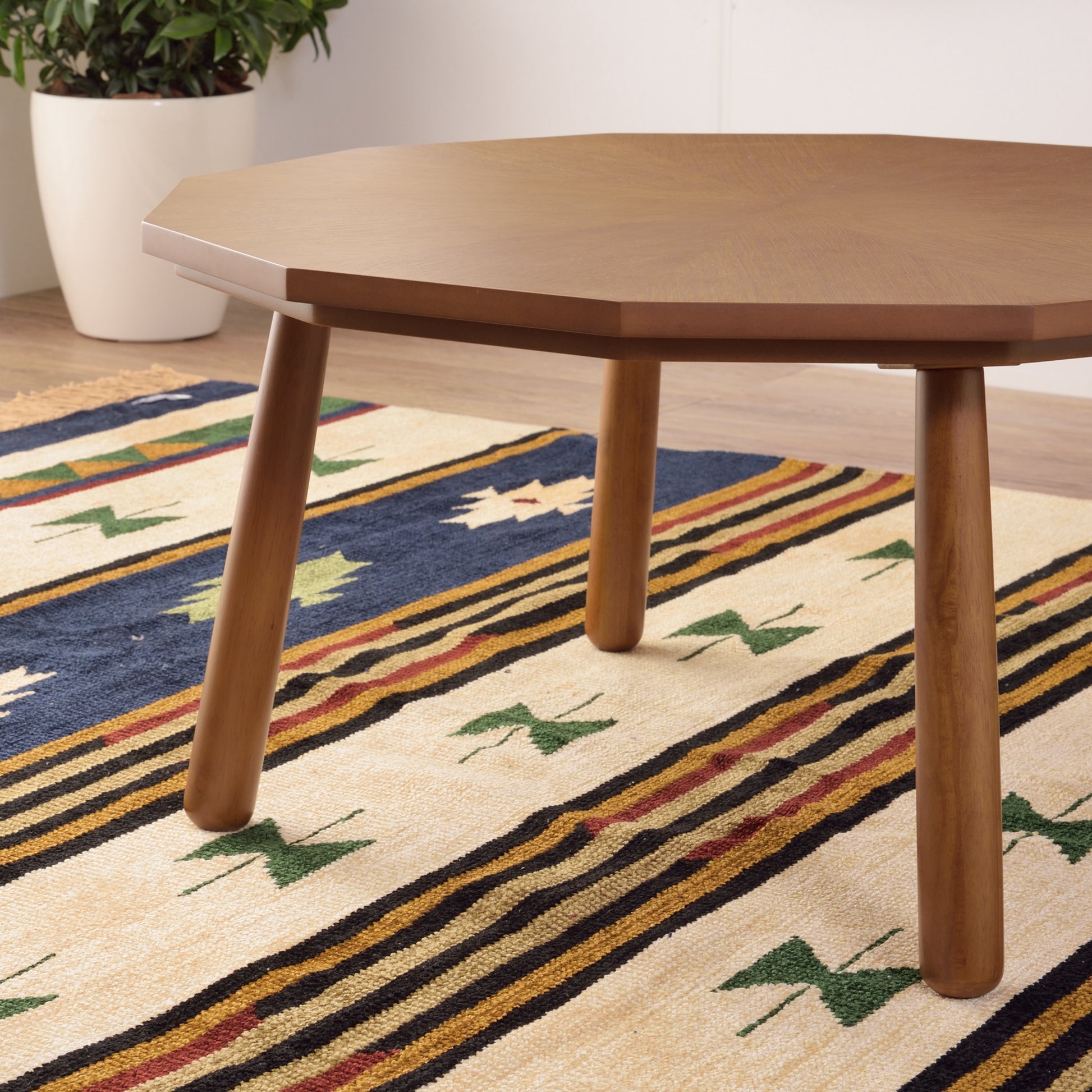 ブラウンの多角形こたつテーブルをローテーブルとして部屋に置いている様子