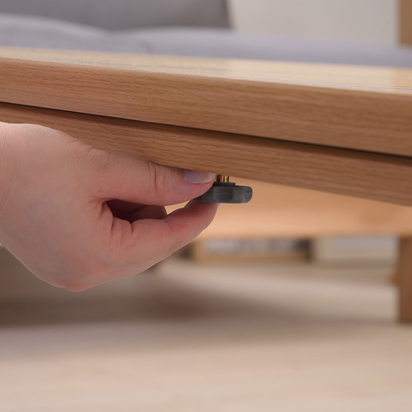 ナチュラルでシンプルなこたつテーブルの土台と天板をネジでとめている様子