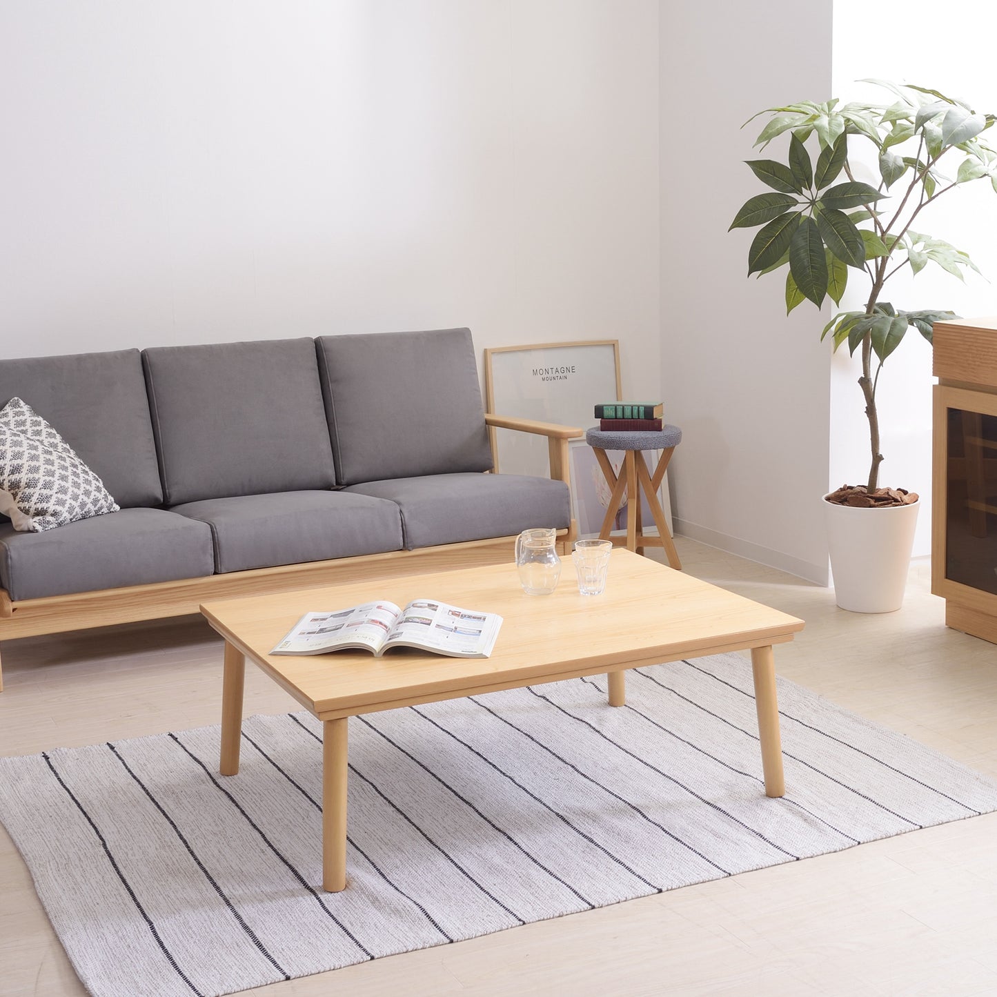 ナチュラルのシンプルなこたつテーブルをローテーブルとして部屋に置いている様子