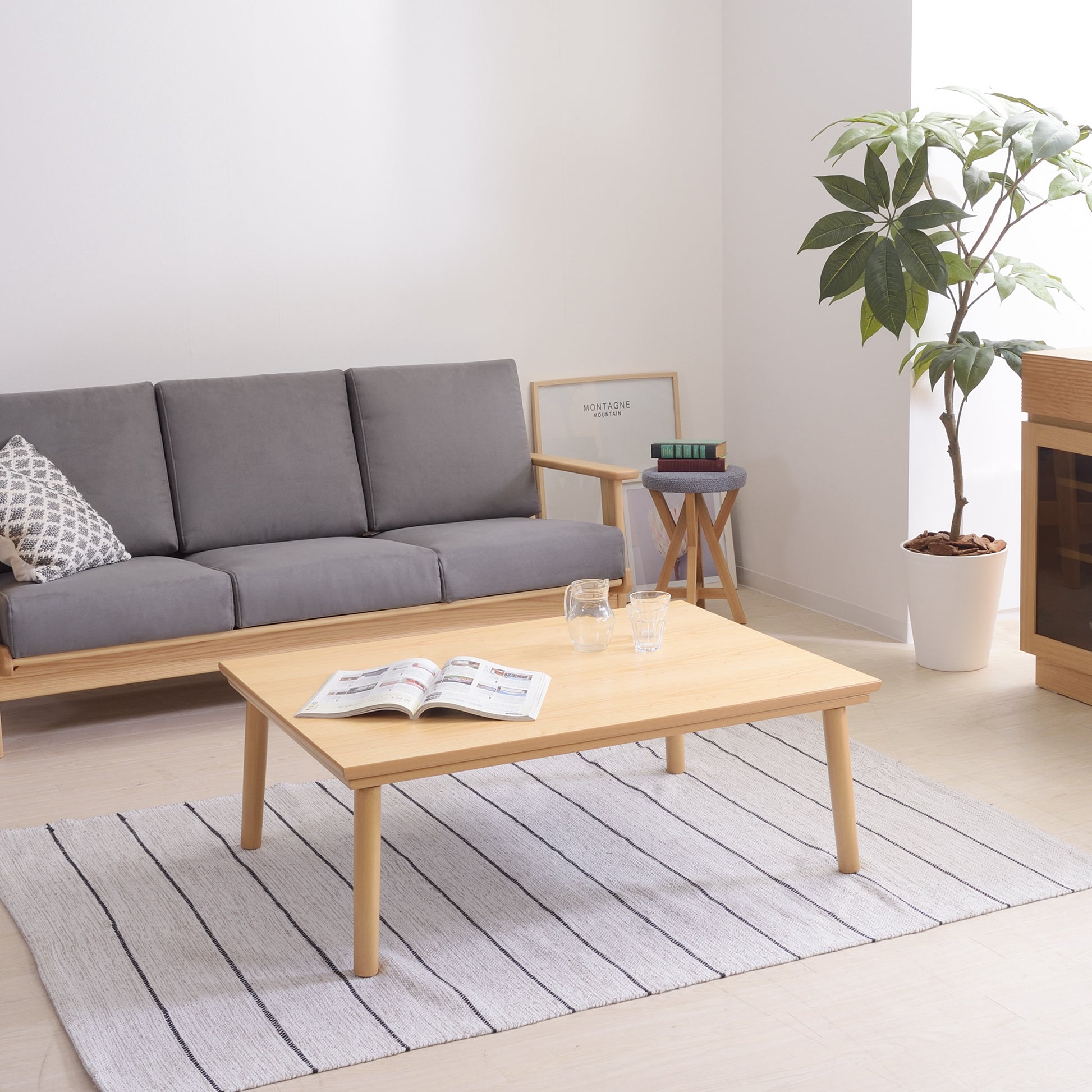 ナチュラルのシンプルなこたつテーブルをローテーブルとして部屋に置いている様子