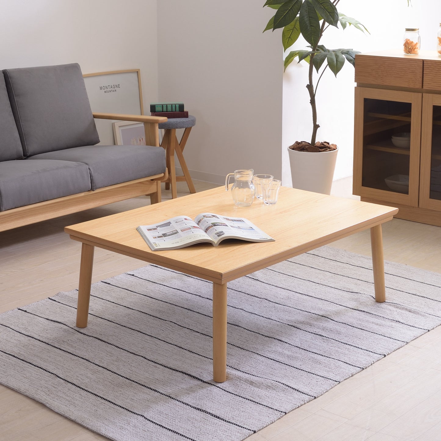 ナチュラルのシンプルなこたつテーブルをローテーブルとして部屋に置いている様子
