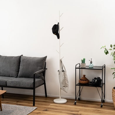 ホワイトのポールハンガーをソファ横に置いている様子