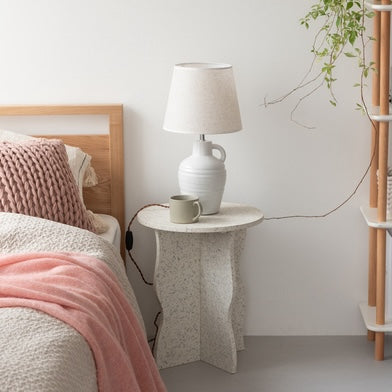 テラゾー柄のウェーブサイドテーブルをベッド横に置いている様子