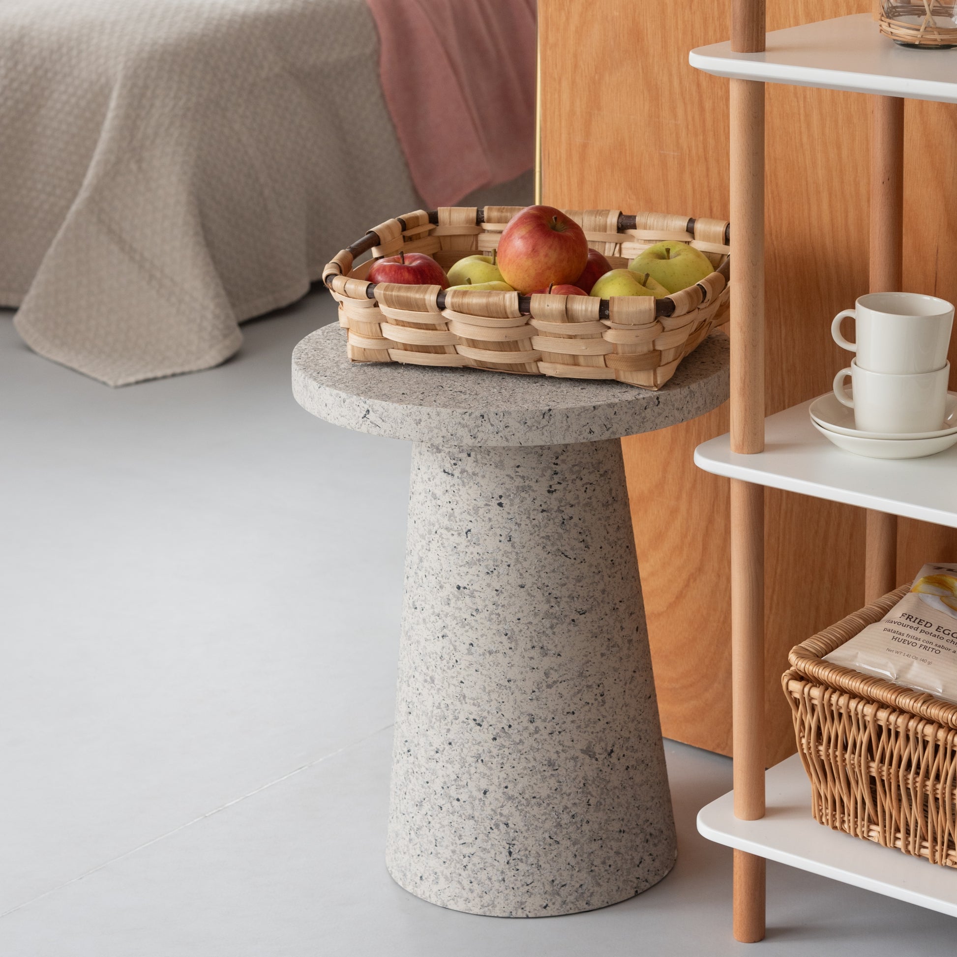 シェルフ横にテラゾー柄ラウンドサイドテーブルが置いてある様子