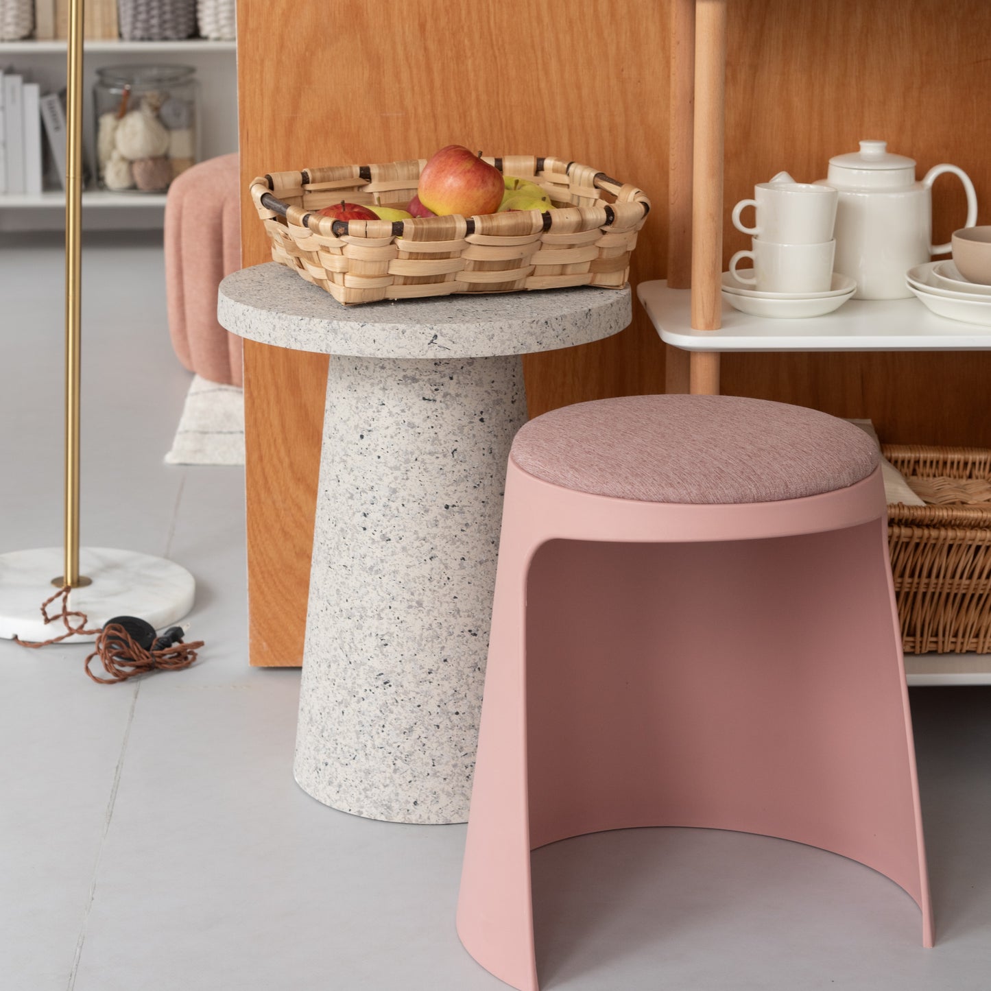 シェルフ横にテラゾー柄ラウンドサイドテーブルが置いてある様子