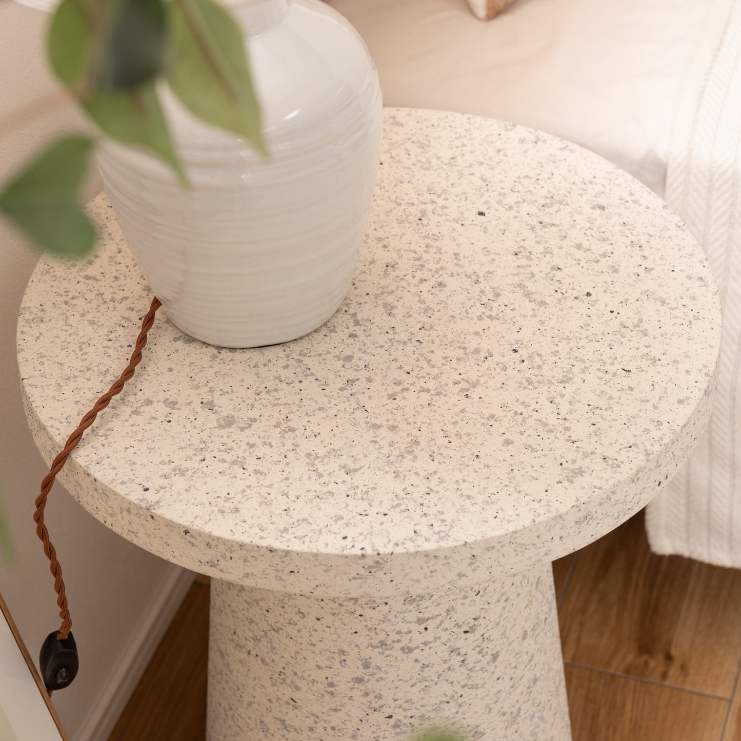 ライトが置かれたテラゾー柄ラウンドサイドテーブルをアップで写している様子