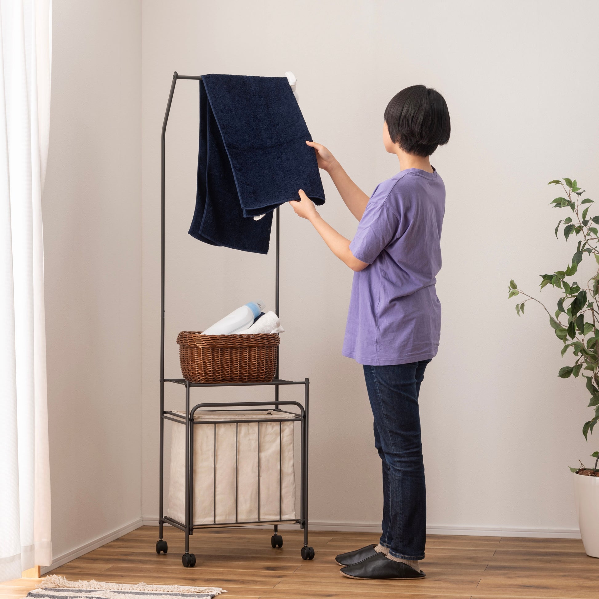 洋服がかけられたバスケット付きランドリーハンガー
