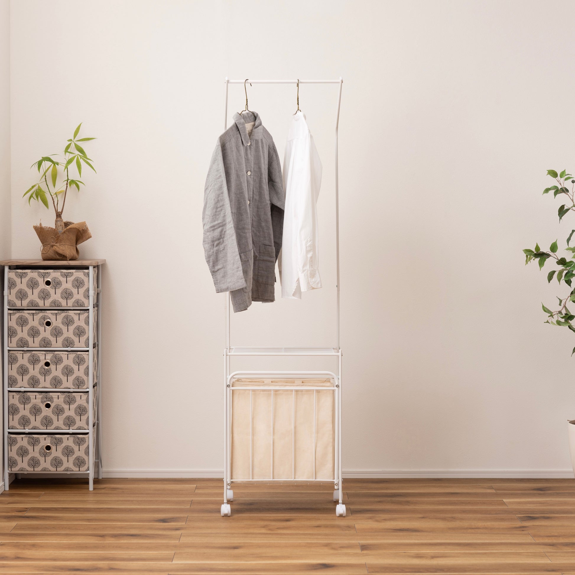 洋服がかけられたバスケット付きランドリーハンガー