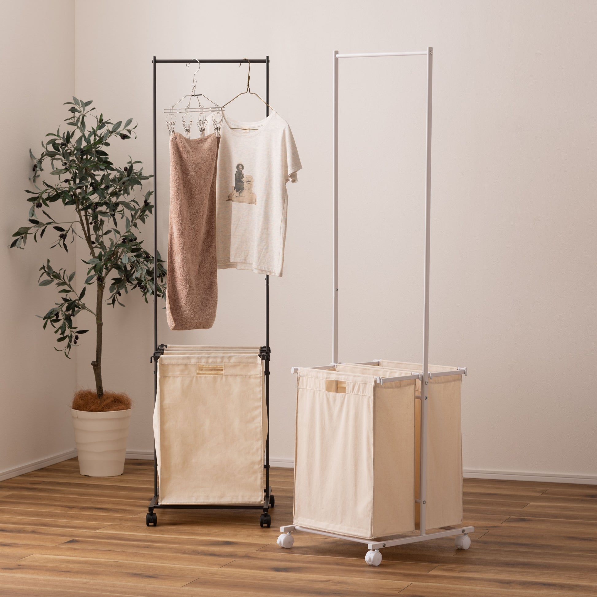 ホワイトとダークグレーのスタイリッシュなスチールフレームの2つカゴ付きランドリーハンガーが2つ並んだ様子