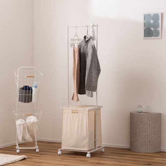 スタイリッシュなスチールフレームの2つカゴ付きランドリーハンガーが部屋に置いてある写真