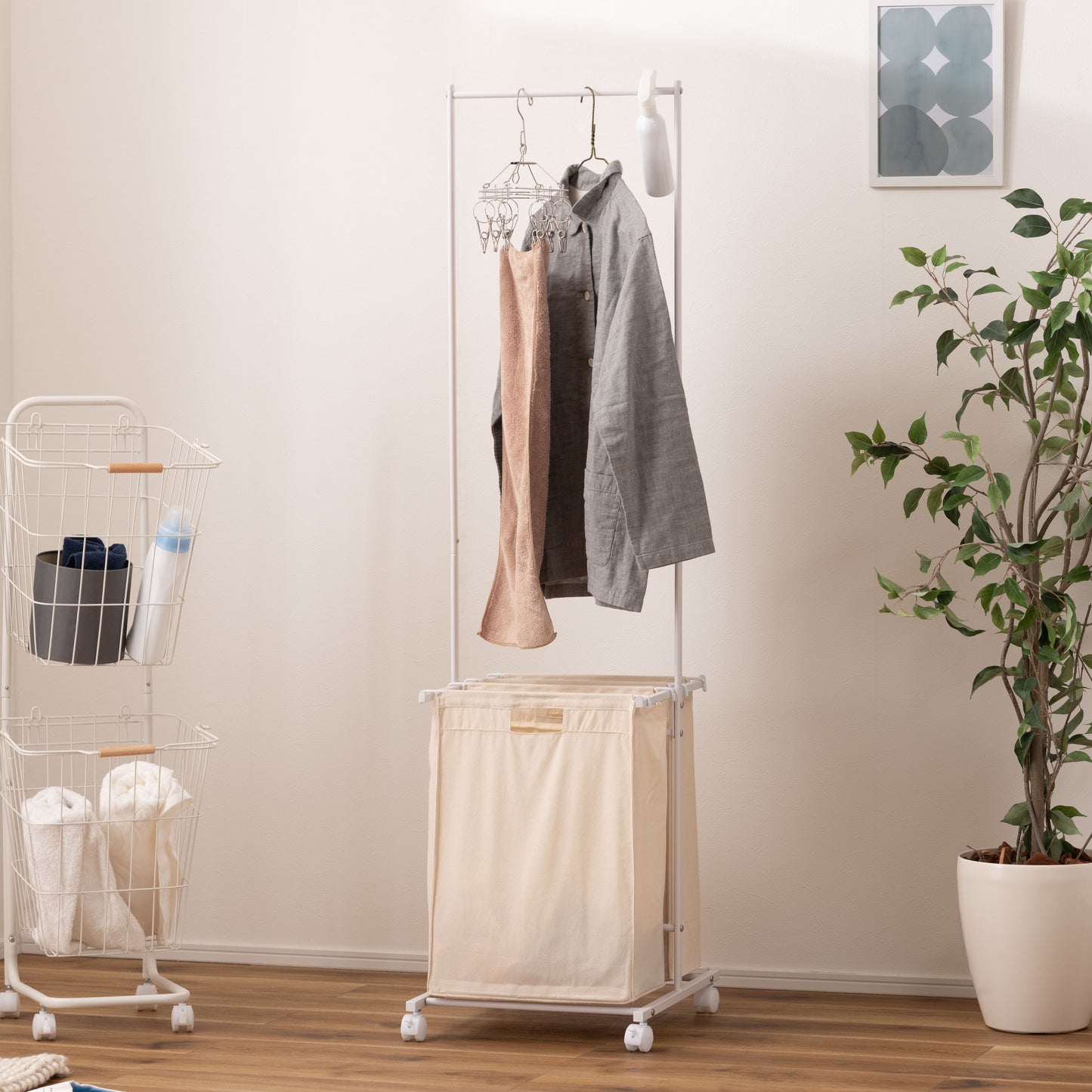 スタイリッシュなスチールフレームの2つカゴ付きランドリーハンガーが部屋に置いてある写真