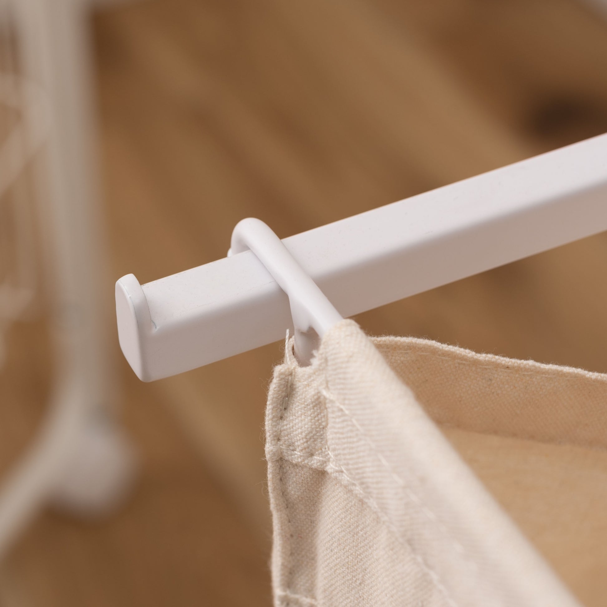 スタイリッシュなスチールフレームの2つカゴ付きランドリーハンガーのバスケットを引っ掛けている部分のアップの写真