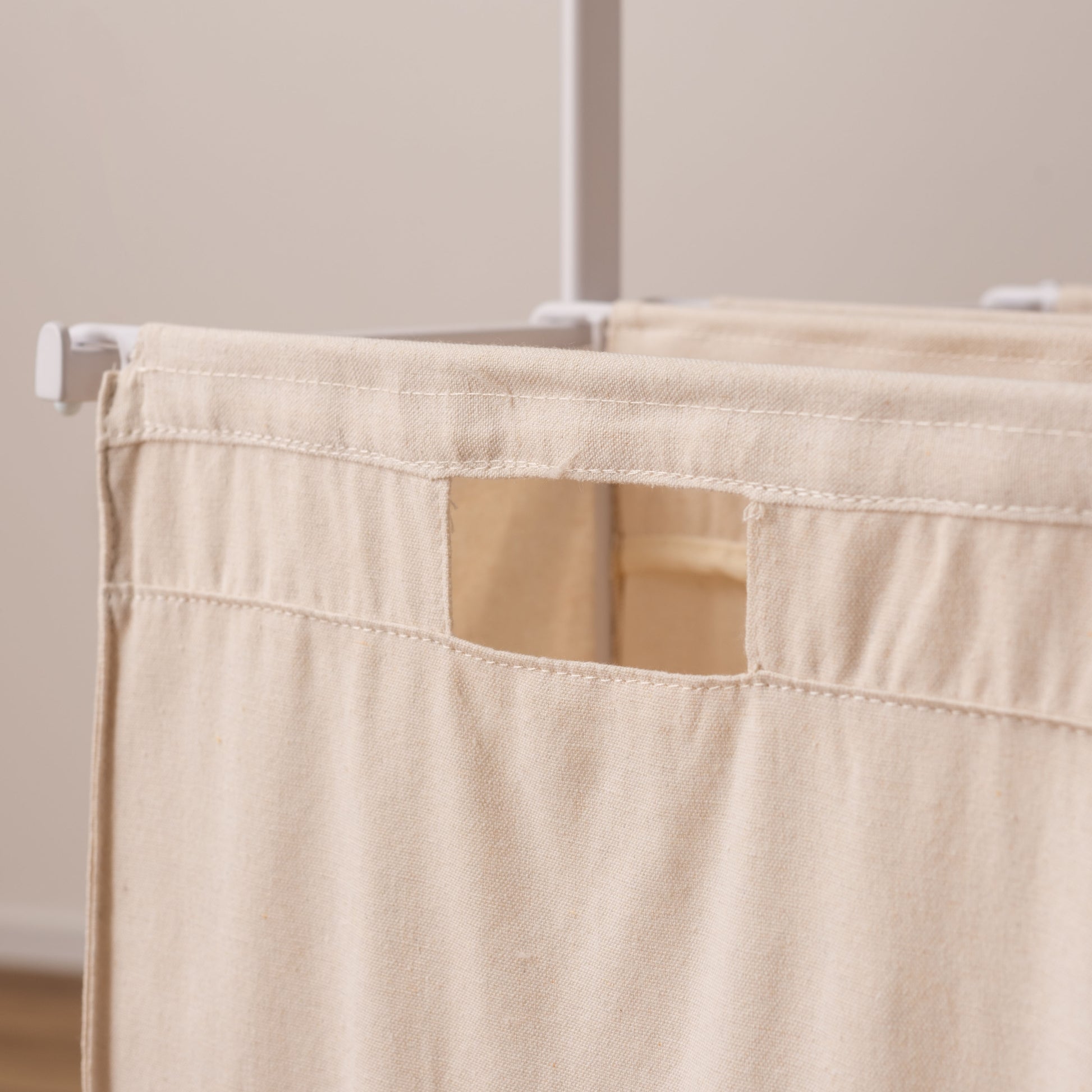 スタイリッシュなスチールフレームの2つカゴ付きランドリーハンガーのキャンバス地のバスケットのアップ