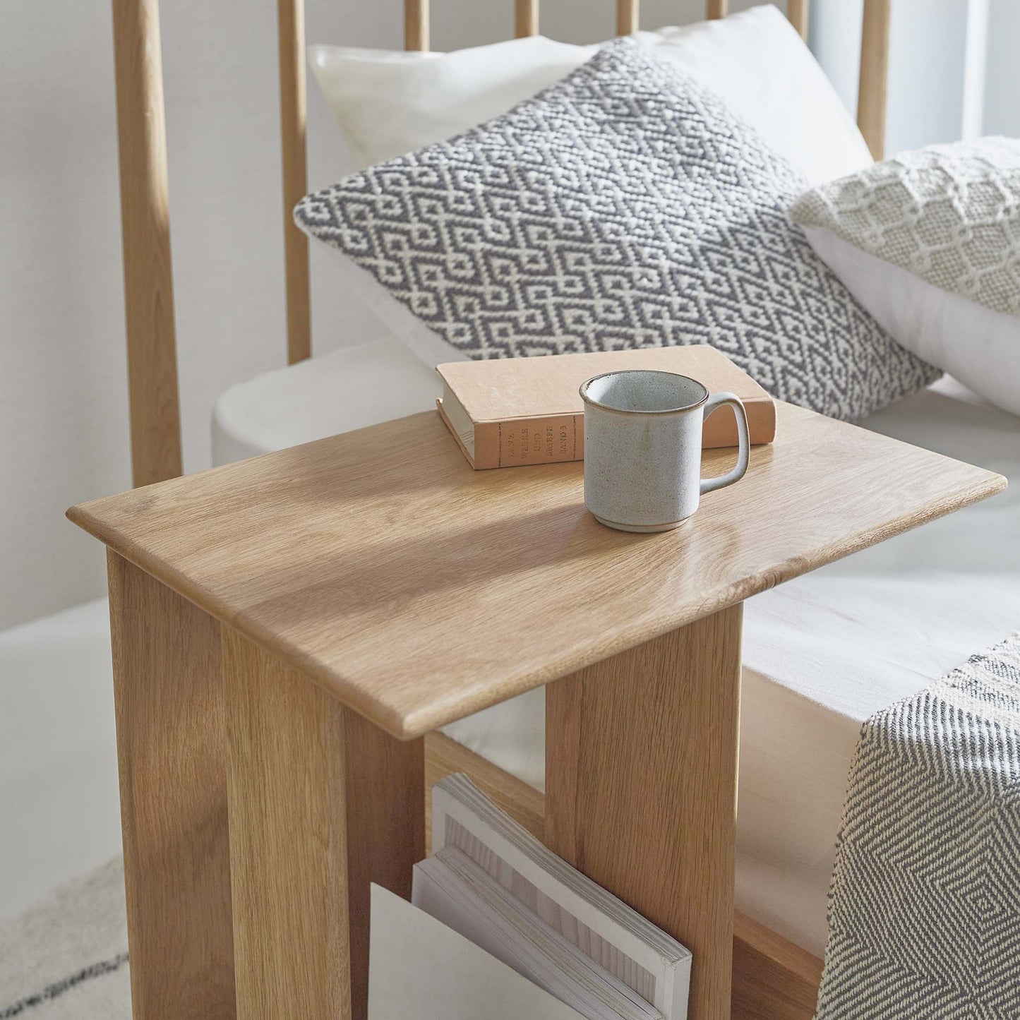 ラック付きオークサイドテーブルの天板にコップと本が置かれている様子