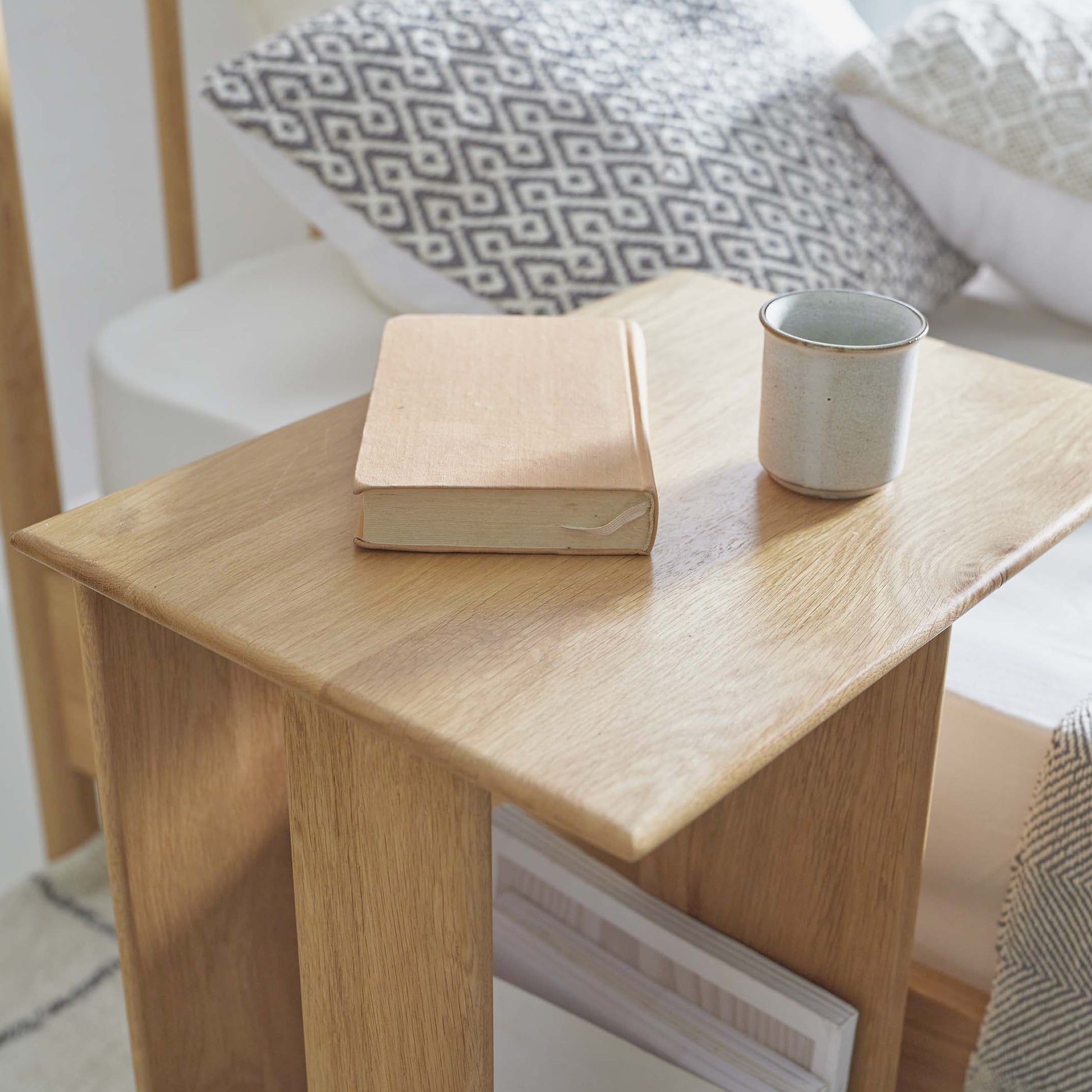ラック付きオークサイドテーブルの天板にコップと本が置かれている様子