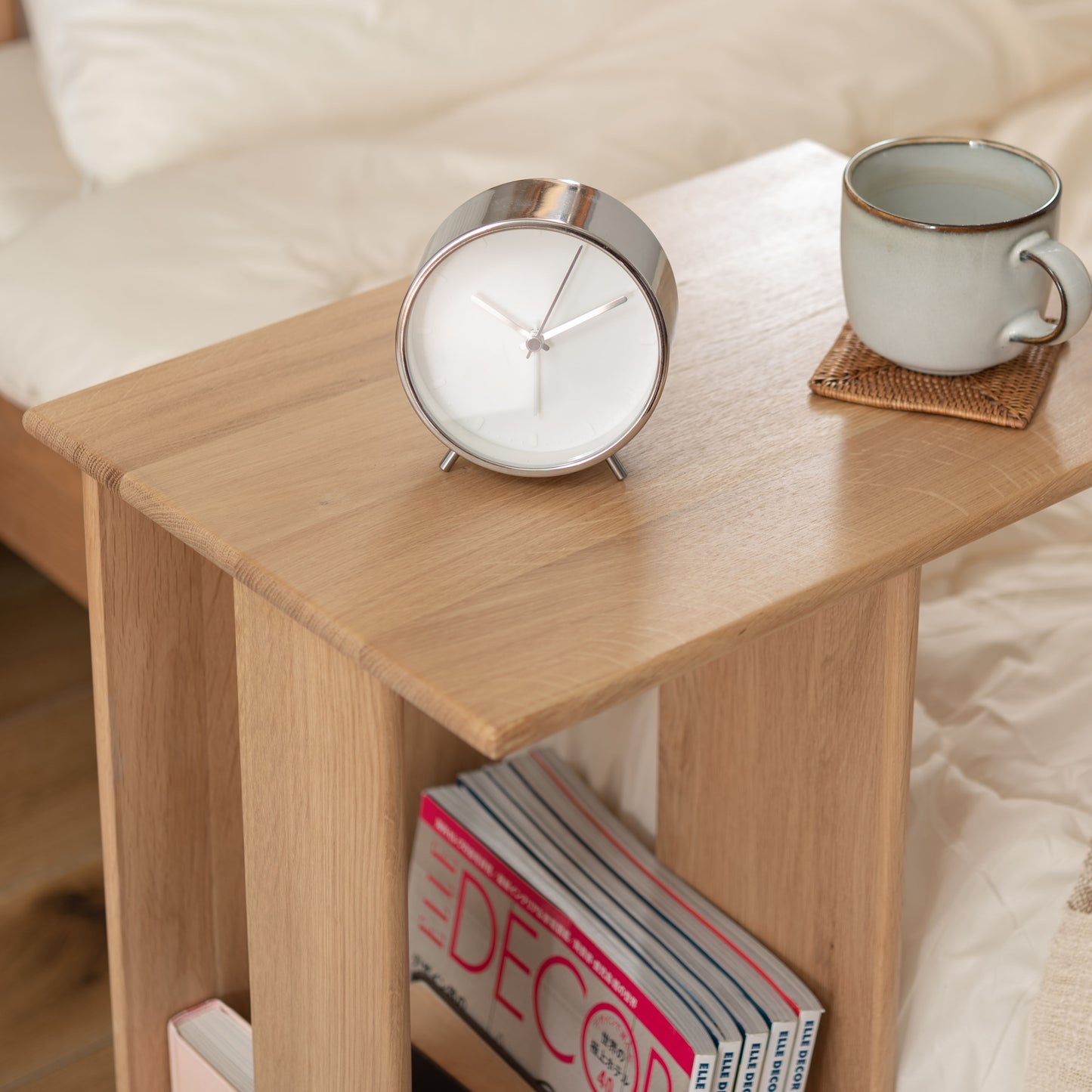 ラック付きオークサイドテーブルの天板にコップと時計が置かれている様子
