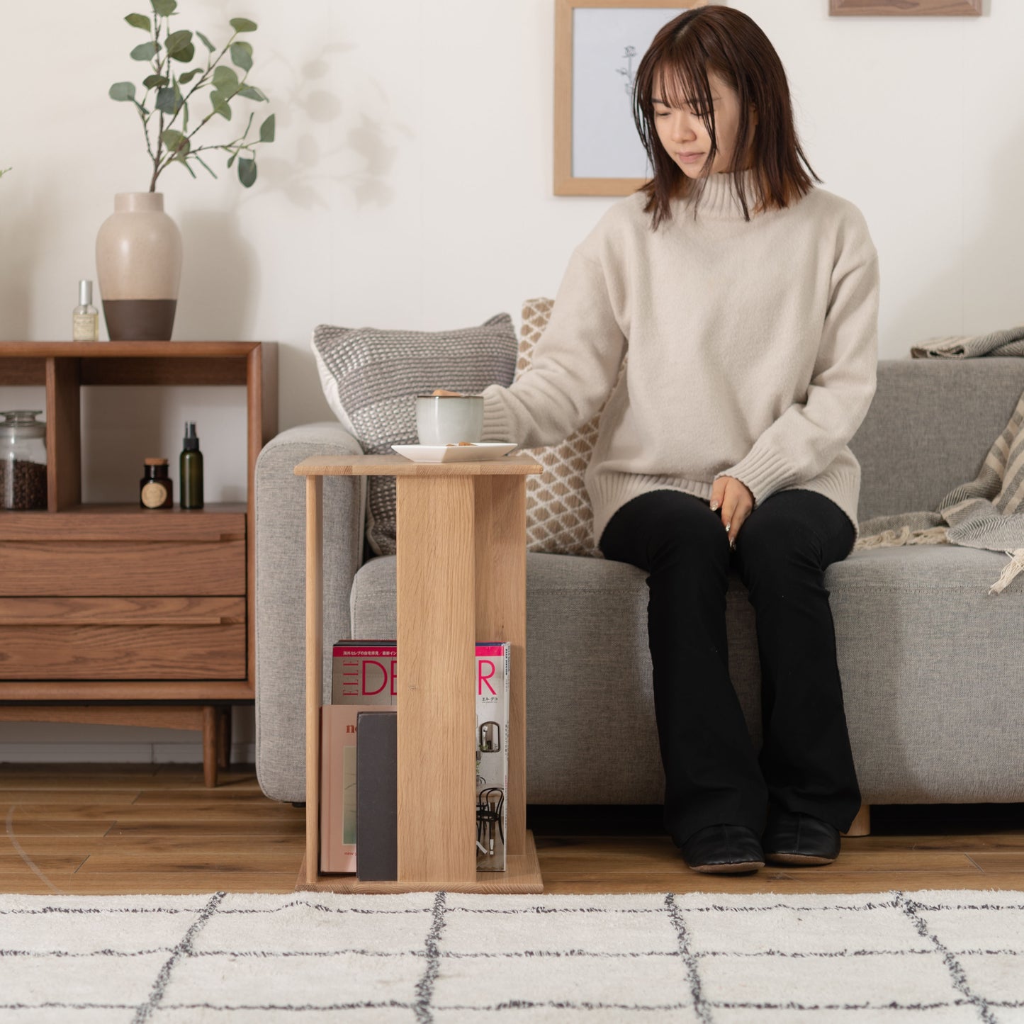 ラック付きオークサイドテーブルをソファ前に置きお茶を飲んでいる様子