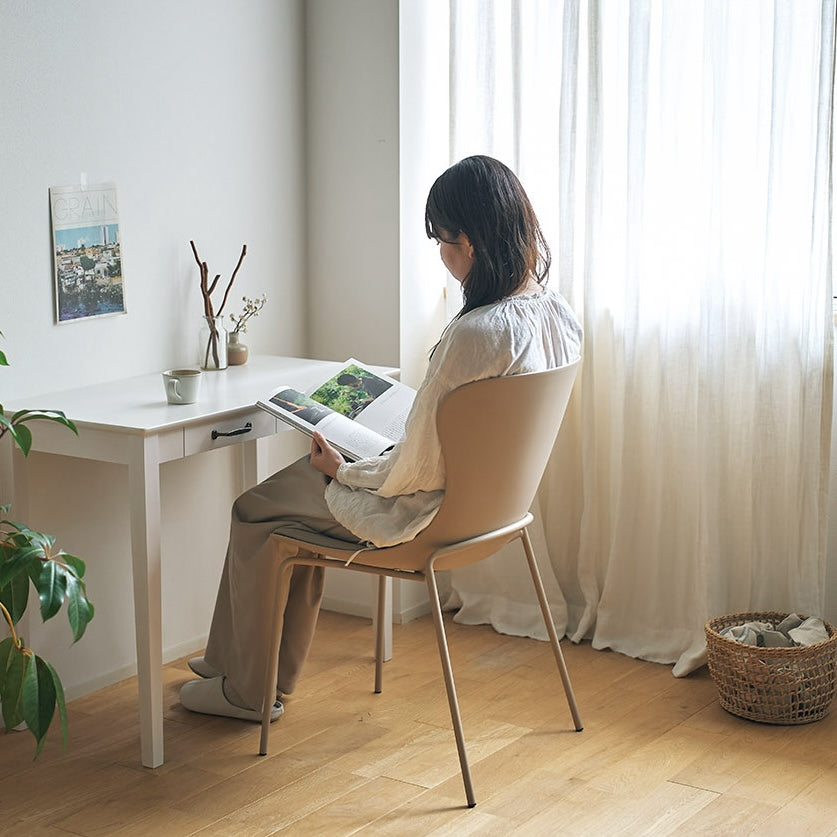 ベージュのダイニンングチェアをデスクチェアとして使っている様子