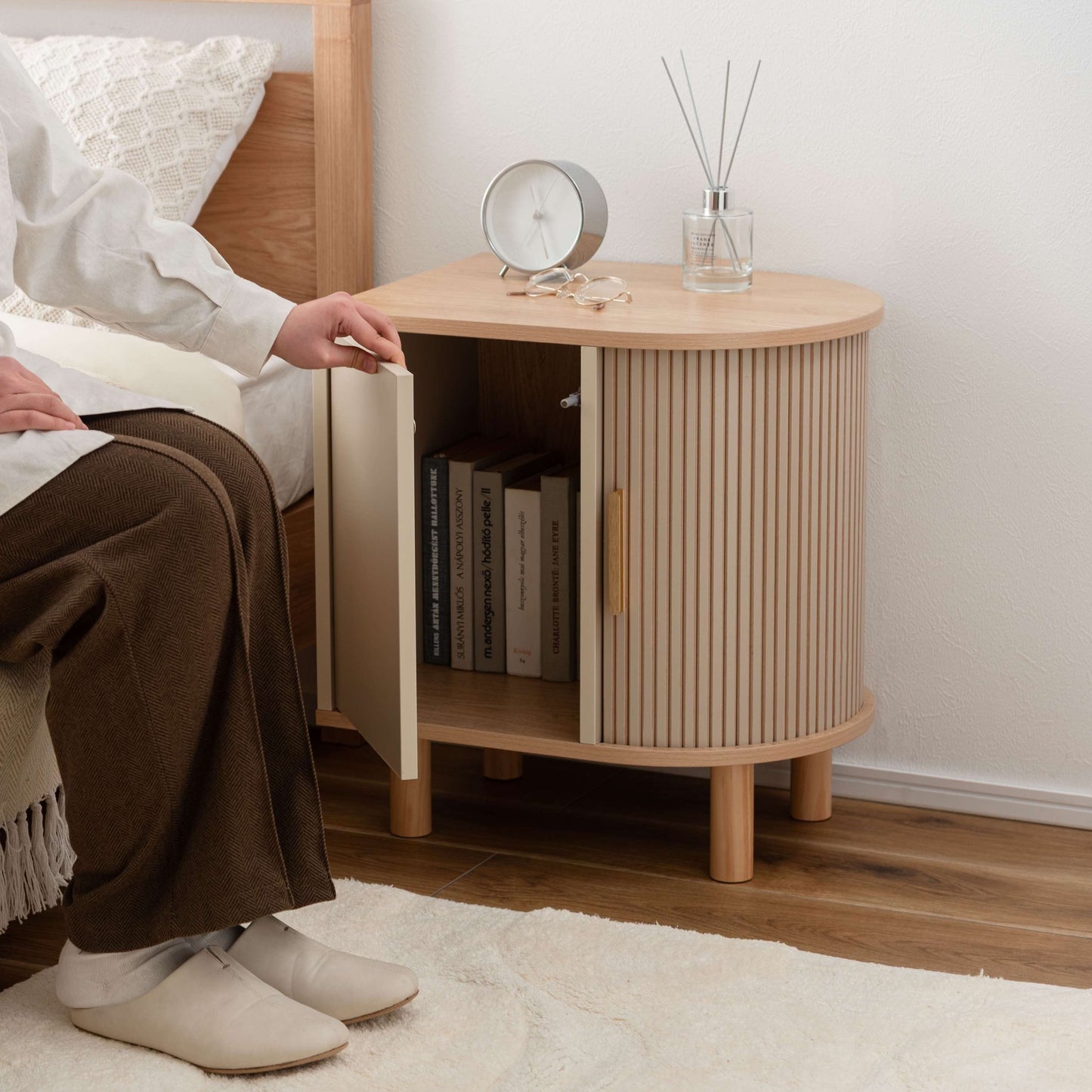 ゴールドとベージュのモダンなデザインのサイドキャビネットがベッドサイドに置いてある部屋