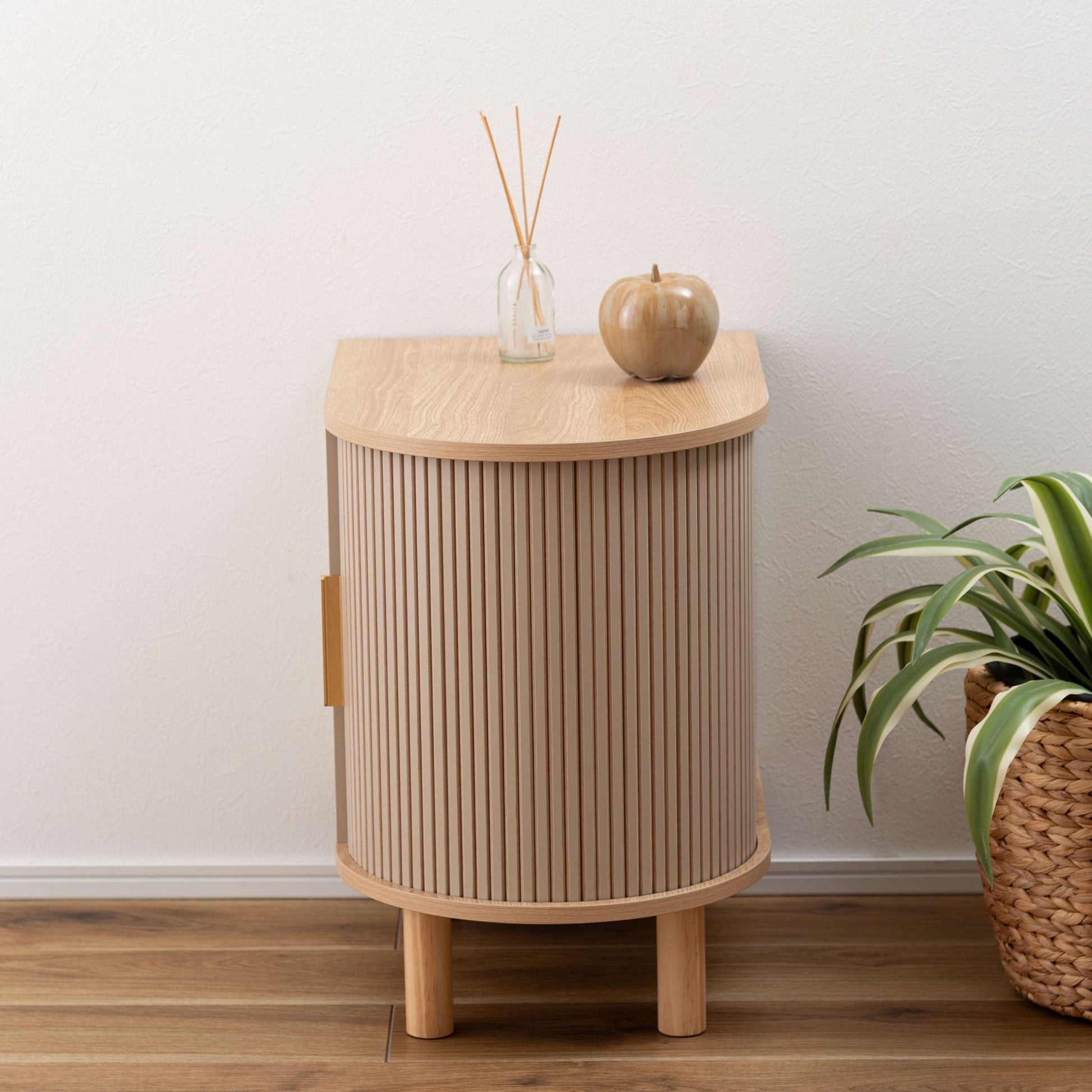 ゴールドとベージュのモダンなデザインのサイドキャビネットがベッドサイドに置いてある部屋