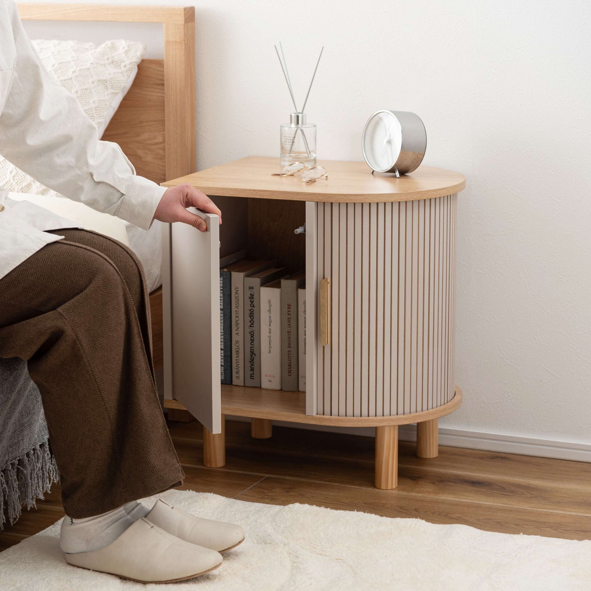 ゴールドとグレージュのモダンなデザインのサイドキャビネットがベッドサイドに置いてある部屋