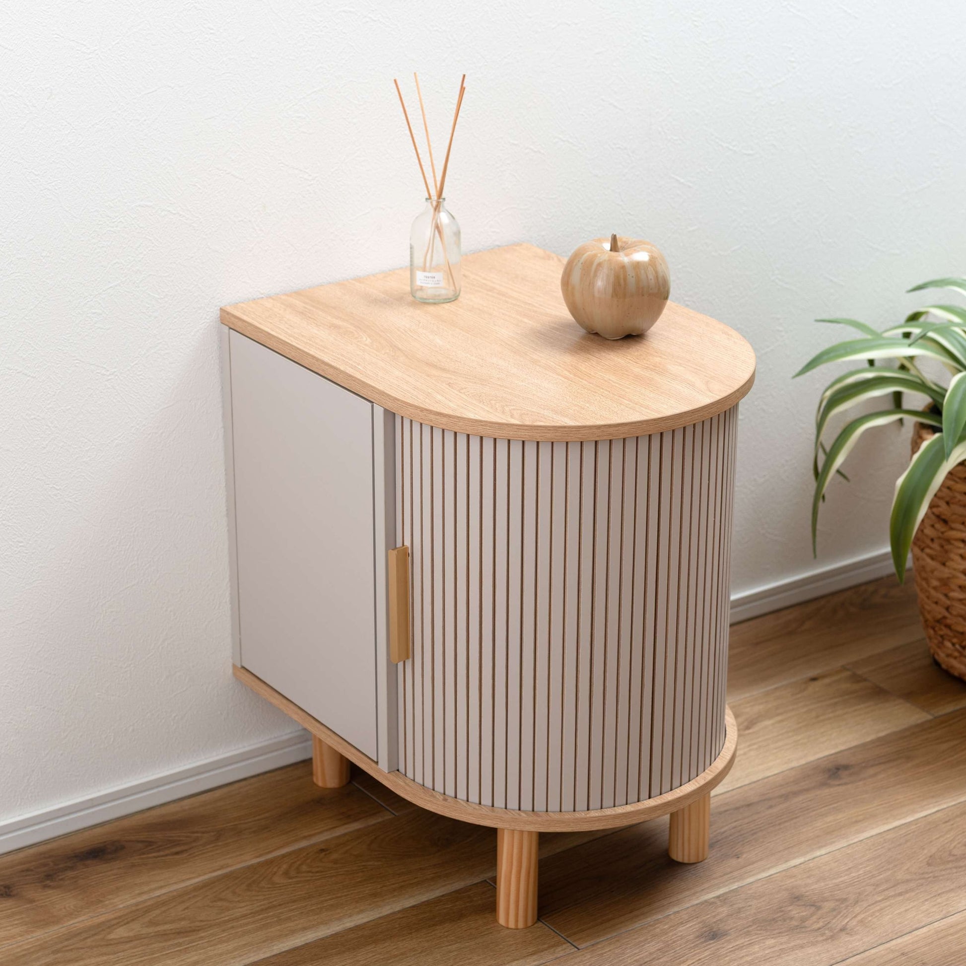 ゴールドとグレージュのモダンなデザインのサイドキャビネットがベッドサイドに置いてある部屋