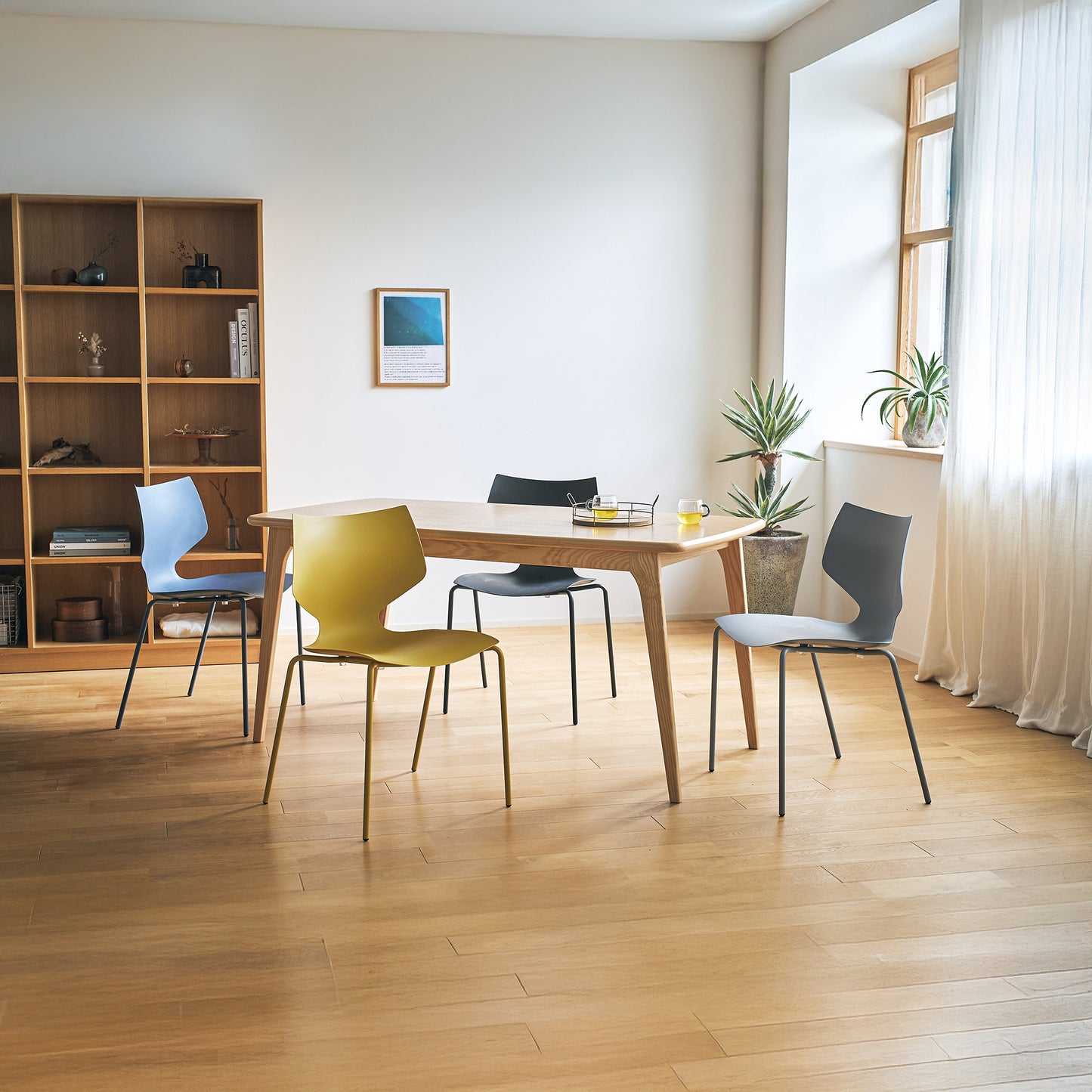 4色展開のスタッキングチェアをダイニングテーブルを囲んで置いている様子