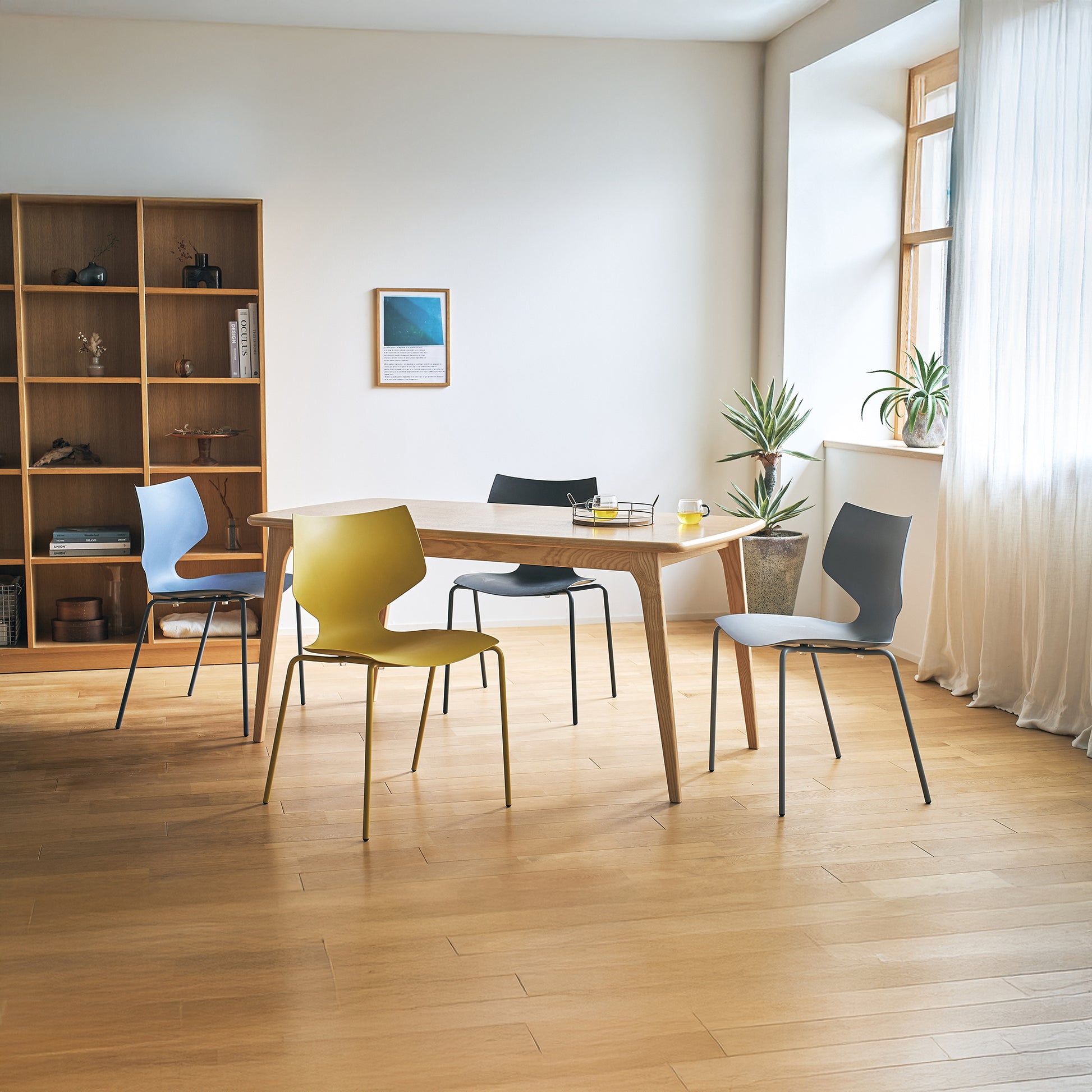 4色展開のスタッキングチェアをダイニングテーブルを囲んで置いている様子