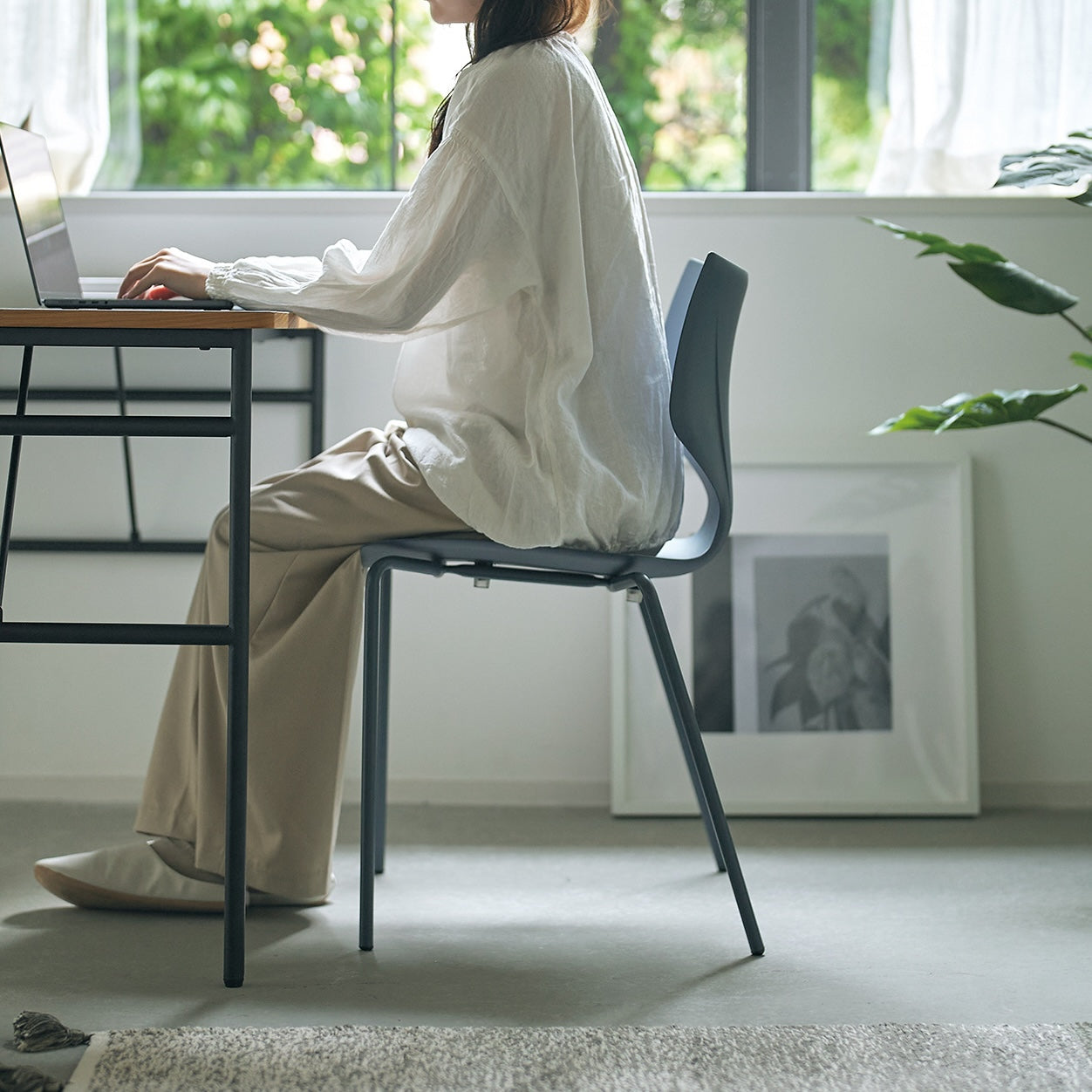 グレーのスタッキングチェアに座っている様子