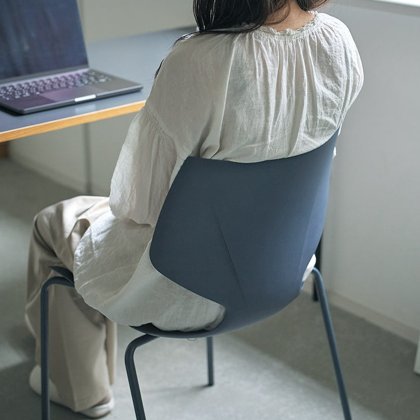 グレーのスタッキングチェアに座っている様子