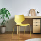 マスタードのスタッキングチェアをデスク前に置いている様子