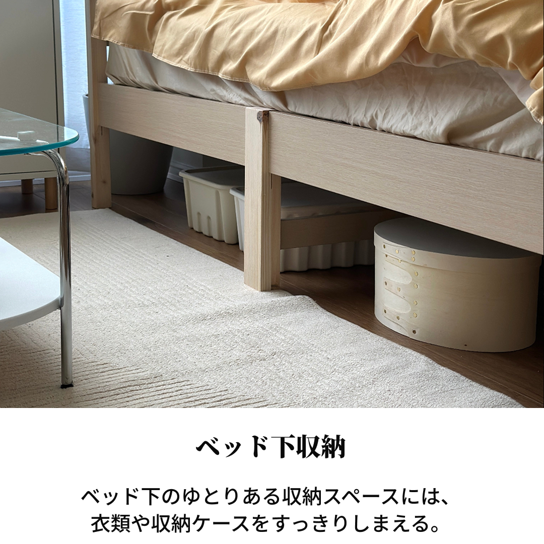クリーム色の円筒形収納ボックスで工具不要組立簡単ラクネベッドの下に置かれています。
