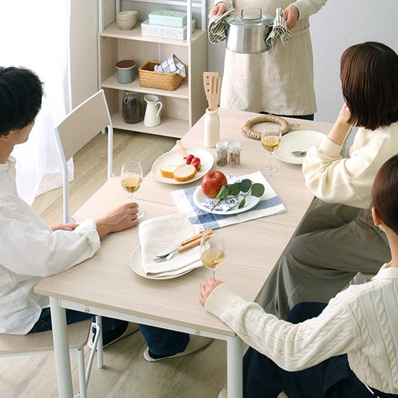 ホワイトの木目調の伸縮ダイニングテーブルを広げて数人で食事している様子