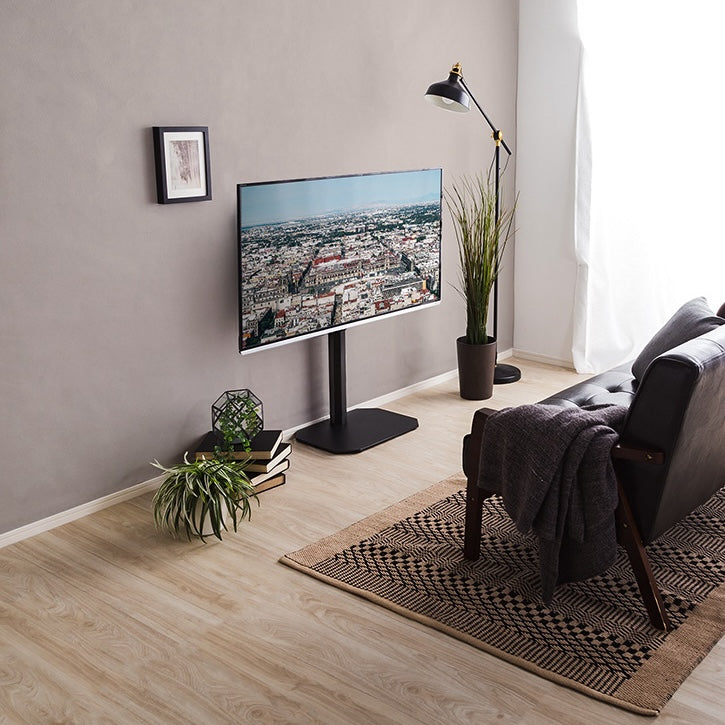 ブラックのシンプルなテレビスタンドがリビングに置かれている様子