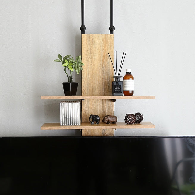 ラックが付いた突っ張りタイプのテレビスタンドにフレグランスや植物が飾られている様子