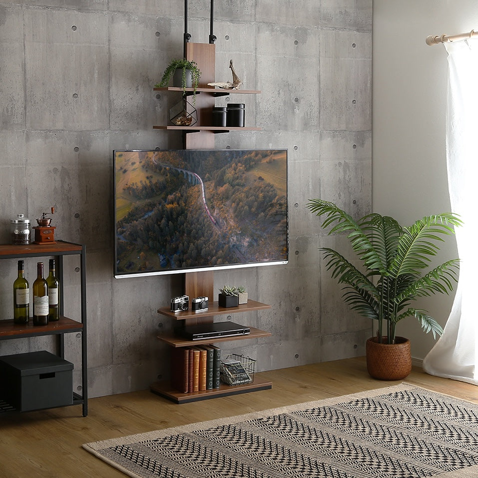 ラックが付いた突っ張りタイプのテレビスタンドがリビングに置かれている様子