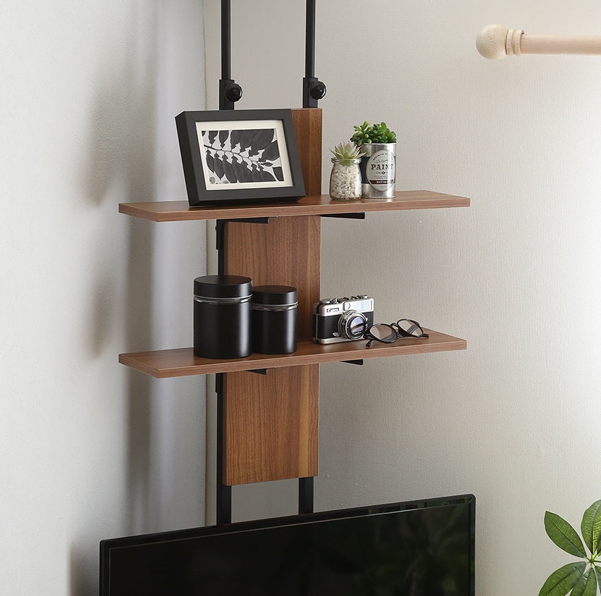 ラックが付いた突っ張りタイプのテレビスタンドにお気に入りのアイテムが飾られている様子