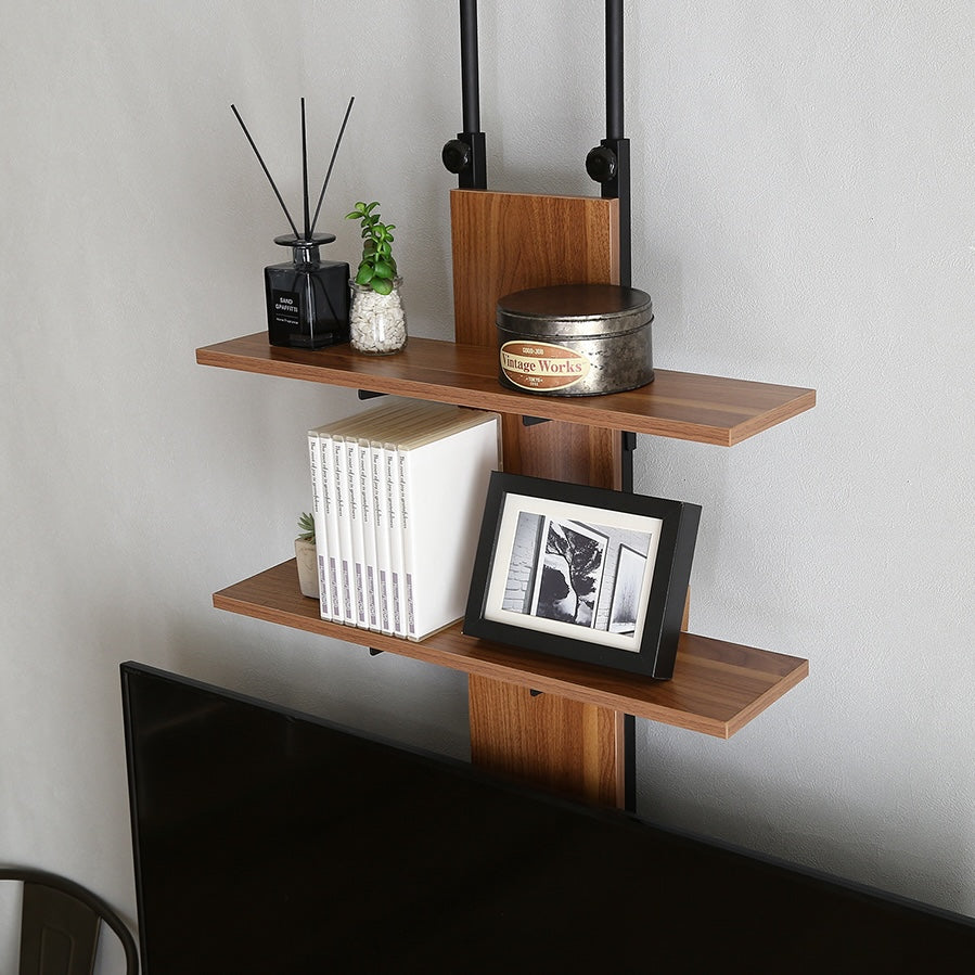 ラックが付いた突っ張りタイプのテレビスタンドにフレグランスや写真が飾られている様子