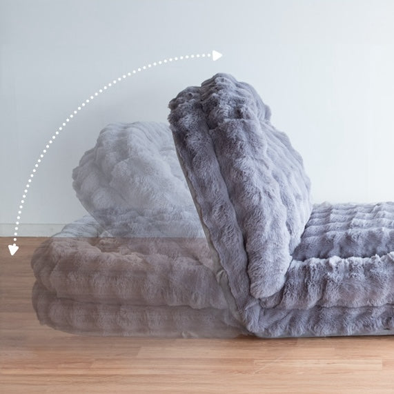 グレーのふわふわな生地のソファベッドがリクライニングであることを示している様子