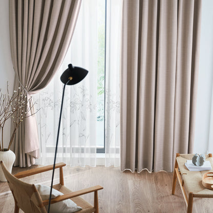 ピーチカラーのツイード生地にミックス感を出した遮光ドレープカーテンを窓にかけたリビング