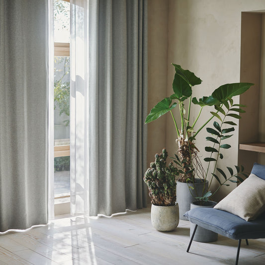 杢調のナチュラルな生地感の遮光1級カーテンが窓にかかった部屋