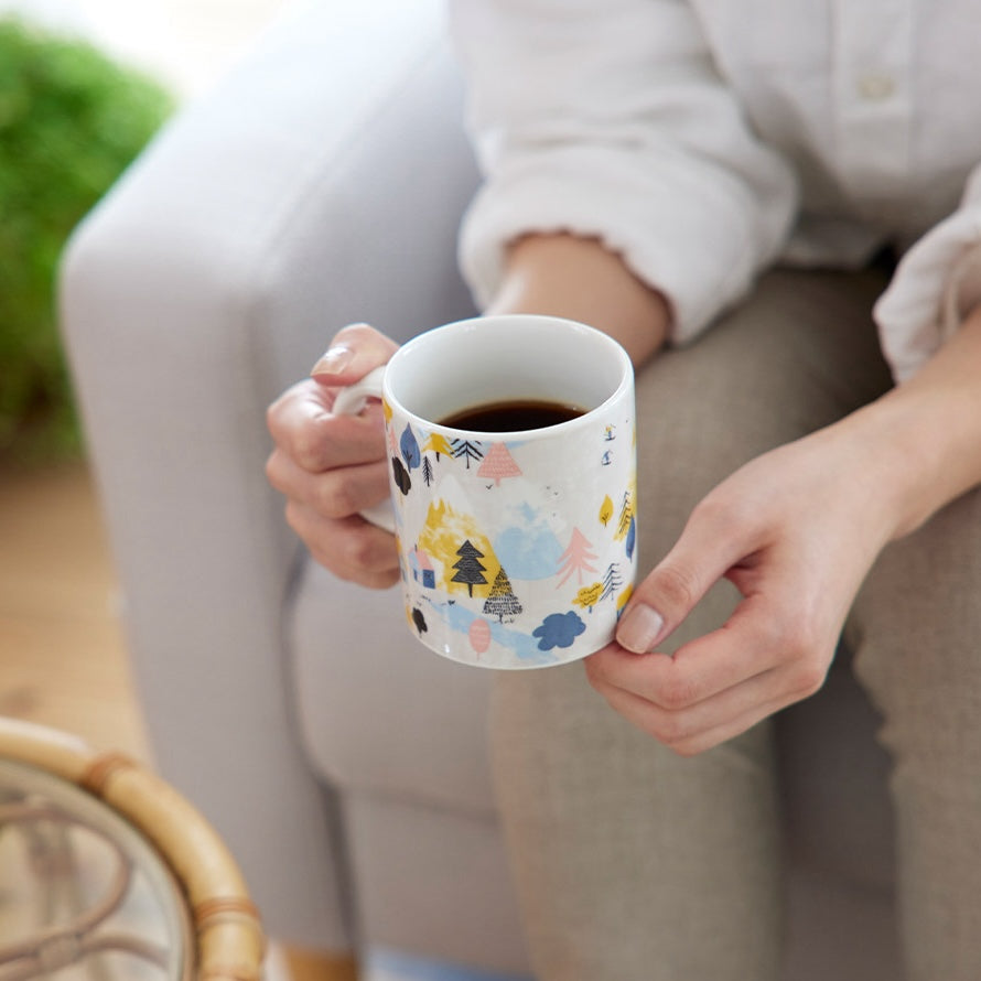 コーヒーの入ったマグカップを手に取っている様子